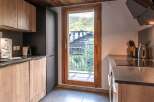 This modern kitchen boasts a sleek design with wooden cabinetry and a dark countertop.