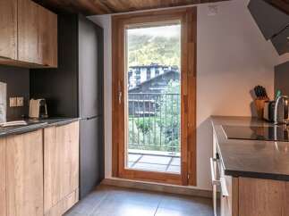 This modern kitchen boasts a sleek design with wooden cabinetry and a dark countertop.