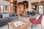 Discover the charm of this stunning property, featuring a cozy living area with a comfortable gray sofa and a stylish red armchair.
