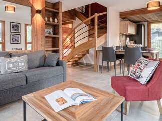 Discover the charm of this stunning property, featuring a cozy living area with a comfortable gray sofa and a stylish red armchair.