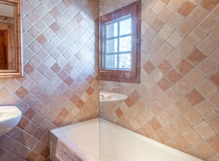 This charming bathroom features a unique tiled design, creating a warm and inviting atmosphere.