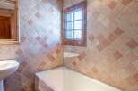 This charming bathroom features a unique tiled design, creating a warm and inviting atmosphere.