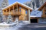This stunning wooden chalet, nestled in a snowy landscape, offers a luxurious retreat.