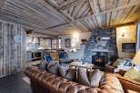 Experience rustic elegance in this stunning property, featuring a cozy living room with a stone fireplace and exposed wooden beams.