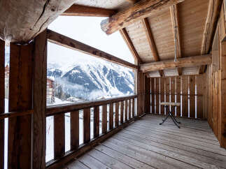Experience breathtaking mountain views from this charming wooden balcony.