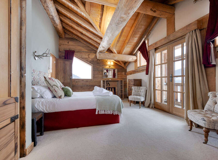 This stunning bedroom features a rustic design with exposed wooden beams and a cozy atmosphere.