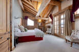 This stunning bedroom features a rustic design with exposed wooden beams and a cozy atmosphere.