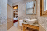 This stunning bathroom features a unique stone sink and a stylish mirror, creating a luxurious and inviting space.