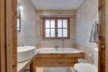 This luxurious bathroom features a stunning wooden bathtub surround, creating a warm and inviting atmosphere.
