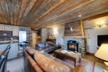 Experience rustic charm in this stunning living space, featuring a cozy fireplace and exposed wooden beams.