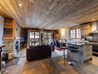 Experience rustic luxury in this stunning chalet, featuring a cozy stone fireplace and exposed wooden beams.