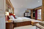 This luxurious bedroom showcases rustic charm with its wooden accent walls and elegant decor.