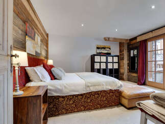 This luxurious bedroom showcases rustic charm with its wooden accent walls and elegant decor.