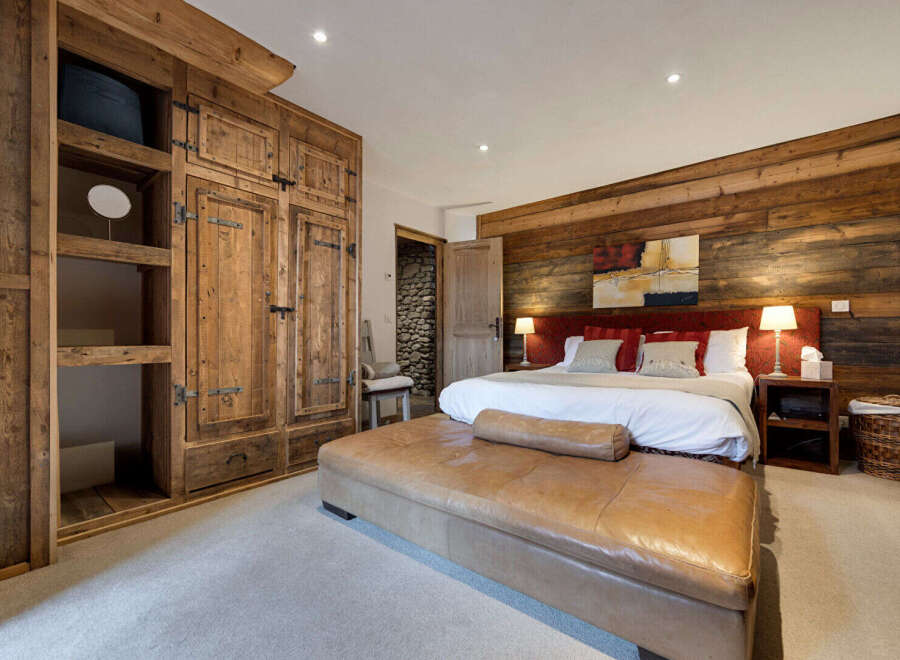 Step into luxury with this stunning bedroom featuring rustic wooden accents and a cozy ambiance.