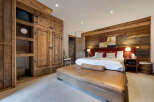 Step into luxury with this stunning bedroom featuring rustic wooden accents and a cozy ambiance.