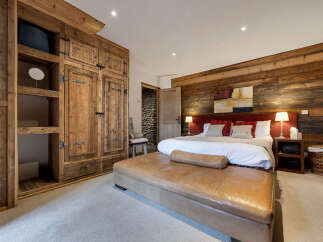 Step into luxury with this stunning bedroom featuring rustic wooden accents and a cozy ambiance.