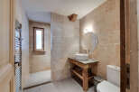 This stunning bathroom boasts a rustic charm with its stone-tiled walls and wooden accents.
