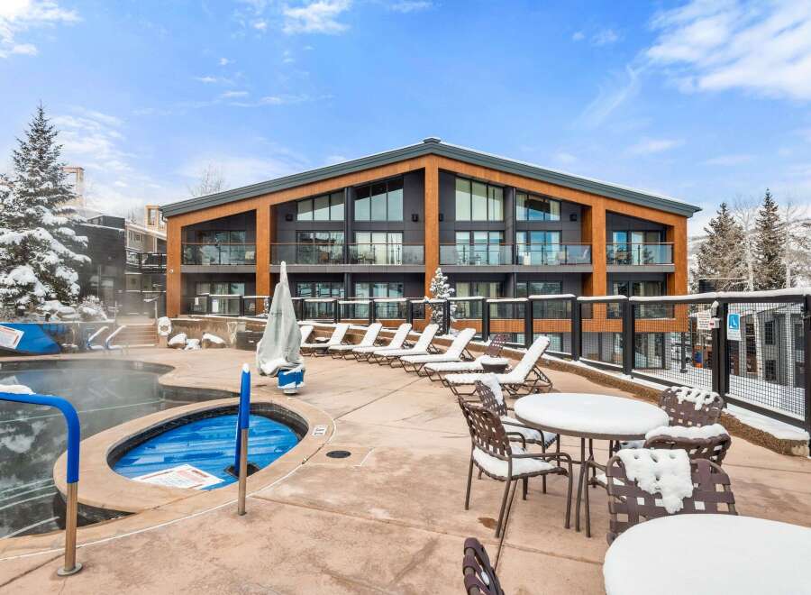 Experience luxury living in this stunning property featuring a hot tub and outdoor seating area, perfect for relaxation.