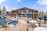 Experience luxury living in this stunning property featuring a hot tub and outdoor seating area, perfect for relaxation.