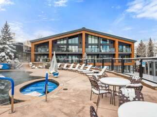 Experience luxury living in this stunning property featuring a hot tub and outdoor seating area, perfect for relaxation.