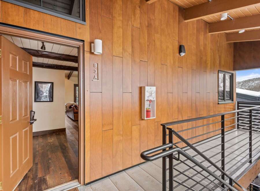 This stunning property boasts a modern design with beautiful wood paneling and a sleek staircase.