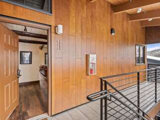 This stunning property boasts a modern design with beautiful wood paneling and a sleek staircase.