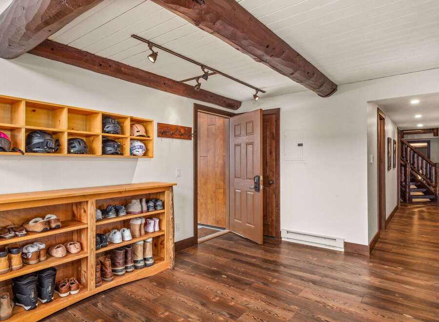 Step into this inviting entryway, showcasing rustic charm with exposed wooden beams and a warm, inviting atmosphere.
