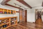 Step into this inviting entryway, showcasing rustic charm with exposed wooden beams and a warm, inviting atmosphere.