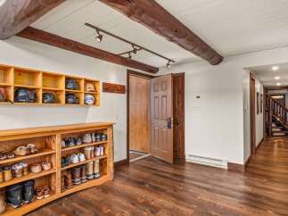 Step into this inviting entryway, showcasing rustic charm with exposed wooden beams and a warm, inviting atmosphere.
