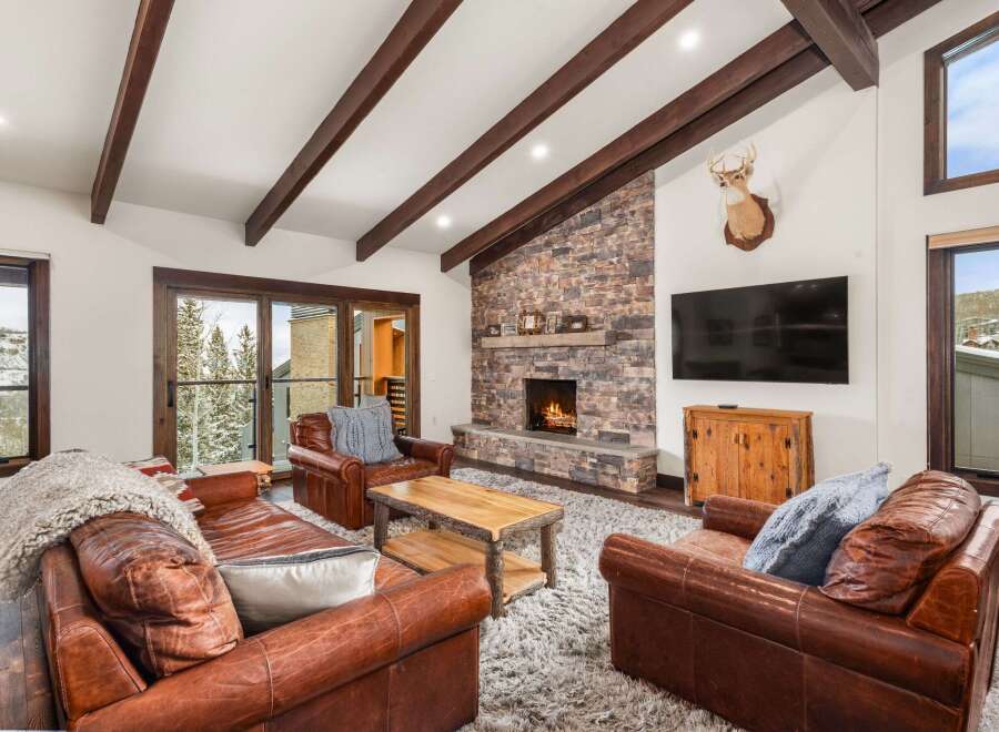Experience luxury living in this stunning property, featuring a cozy living room with a stone fireplace, perfect for chilly evenings.