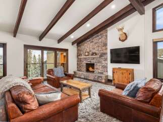 Experience luxury living in this stunning property, featuring a cozy living room with a stone fireplace, perfect for chilly evenings.