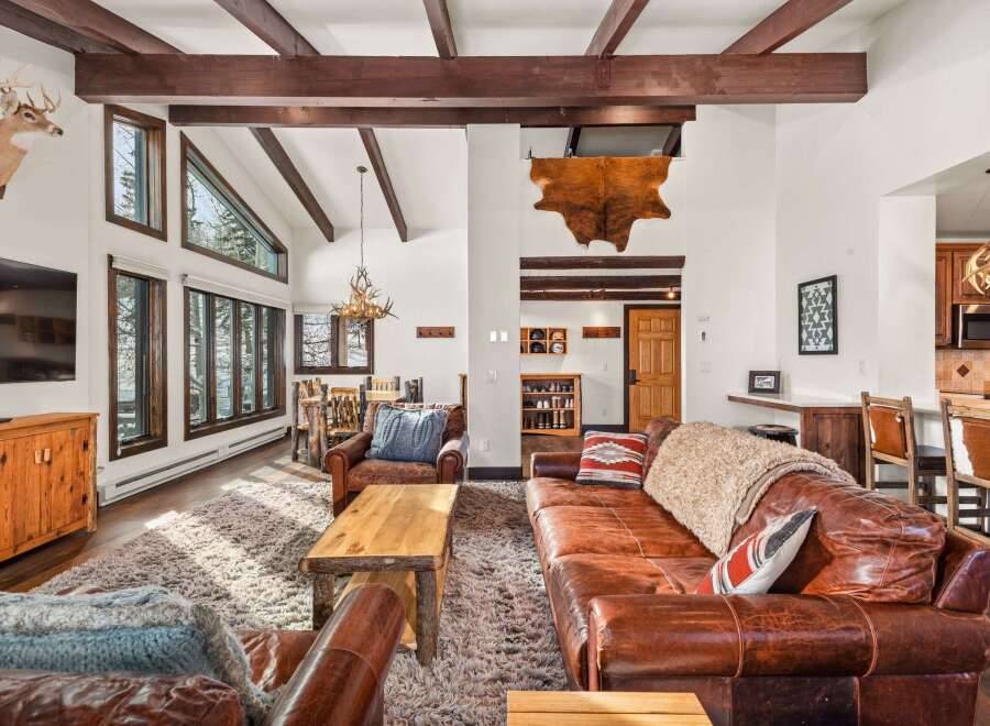This stunning living space boasts a rustic charm with its exposed wooden beams and a cozy, inviting atmosphere.