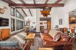 This stunning living space boasts a rustic charm with its exposed wooden beams and a cozy, inviting atmosphere.