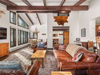 This stunning living space boasts a rustic charm with its exposed wooden beams and a cozy, inviting atmosphere.