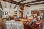 Step into luxury with this stunning property, featuring a spacious living area with exposed wooden beams and a cozy fireplace.