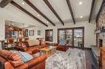 Step into luxury with this stunning living space, boasting a cozy leather sofa and a plush rug, perfect for relaxing after a day on the slopes.