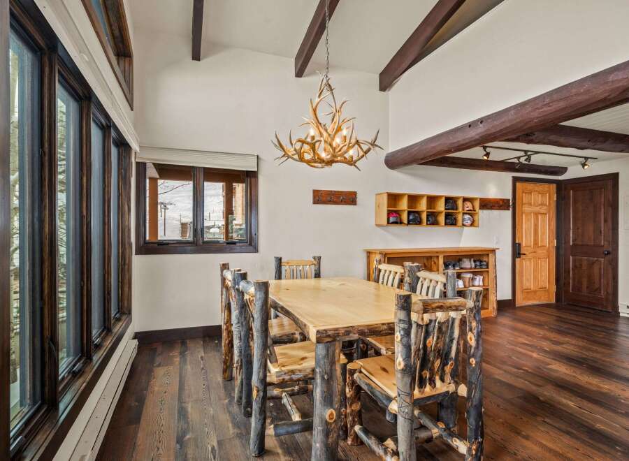 Step into rustic elegance with this stunning dining room! Featuring a unique antler chandelier, a custom wooden dining table, and log-style chairs, this space exudes warmth and charm.