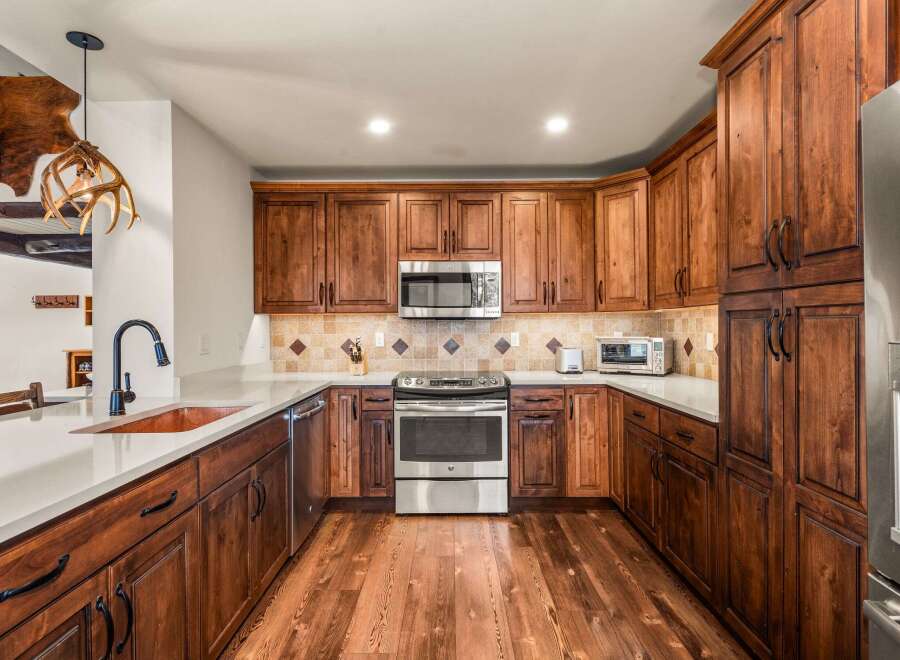 This stunning kitchen boasts custom cabinetry and stainless steel appliances, creating a warm and inviting atmosphere.
