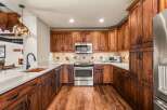 This stunning kitchen boasts custom cabinetry and stainless steel appliances, creating a warm and inviting atmosphere.