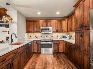 This stunning kitchen boasts custom cabinetry and stainless steel appliances, creating a warm and inviting atmosphere.