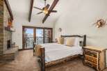 This stunning bedroom boasts rustic charm with its log-style bed frame and cozy fireplace.