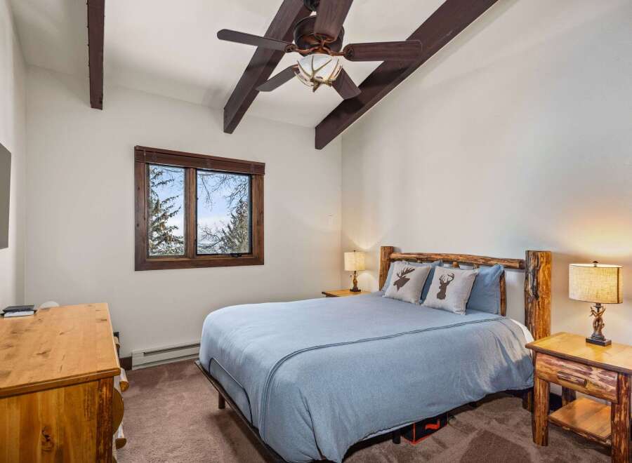 This cozy bedroom features a rustic design with wooden accents and a serene atmosphere.