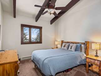 This cozy bedroom features a rustic design with wooden accents and a serene atmosphere.