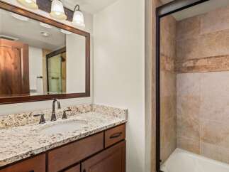 This stunning bathroom features a beautiful granite countertop and a stylish vanity with ample storage.