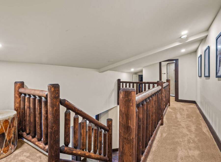 This stunning property features a rustic staircase with a unique log railing, adding a touch of natural elegance.