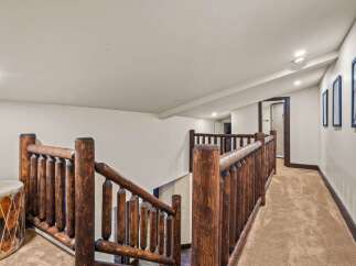 This stunning property features a rustic staircase with a unique log railing, adding a touch of natural elegance.