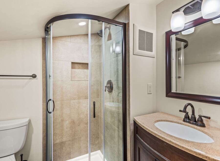 Step into this beautifully designed bathroom featuring a modern glass shower enclosure.
