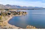 Discover your dream home with stunning lake and mountain views! This property offers a serene escape with a private beach and lush greenery.