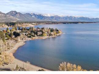 Discover your dream home with stunning lake and mountain views! This property offers a serene escape with a private beach and lush greenery.