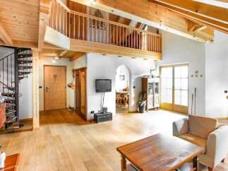 This stunning property boasts a unique architectural design with exposed wooden beams and a charming spiral staircase.